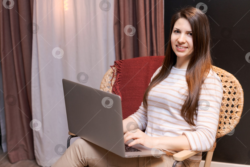 Скачать В кресле сидит женщина, перед ней ноутбук фотосток Ozero