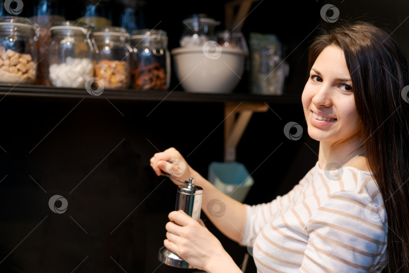 Скачать Женщина улыбается и держит в руках мясорубку для перца фотосток Ozero