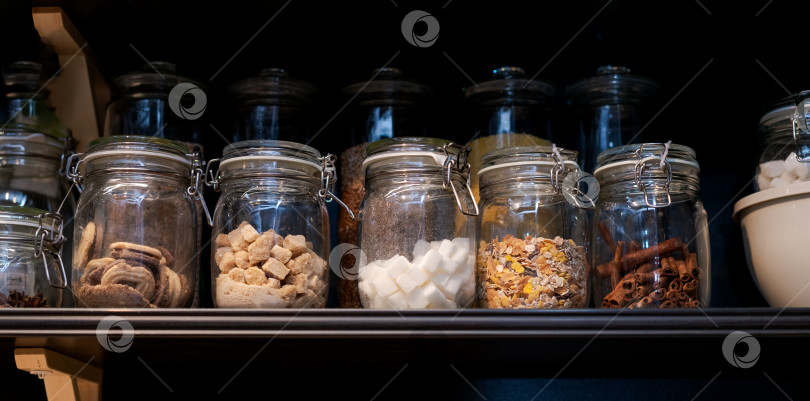 Скачать Полка, заставленная стеклянными банками с различными продуктами внутри фотосток Ozero