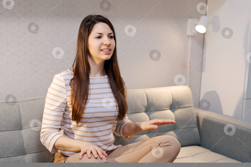 Скачать Женщина, сидящая на диване, уперев руки в бока фотосток Ozero