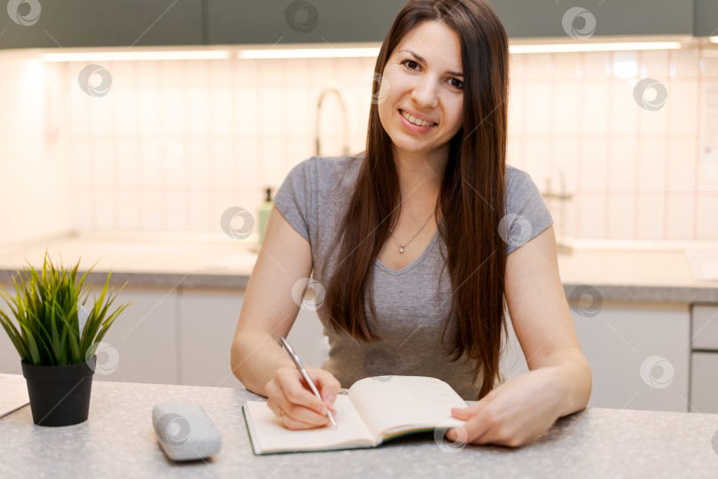 Скачать За столом сидит женщина с блокнотом и ручкой фотосток Ozero