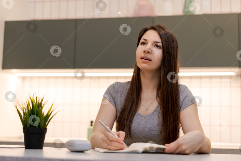 Скачать За столом сидит женщина с блокнотом и ручкой фотосток Ozero