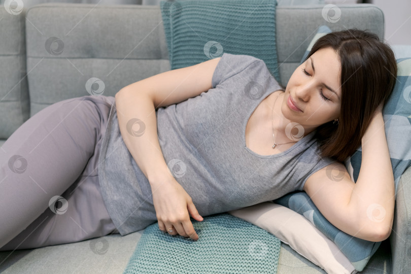 Скачать Женщина лежит на диване, положив голову на подушку фотосток Ozero