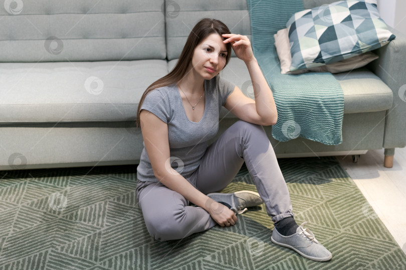 Скачать Женщина сидит на полу в гостиной фотосток Ozero