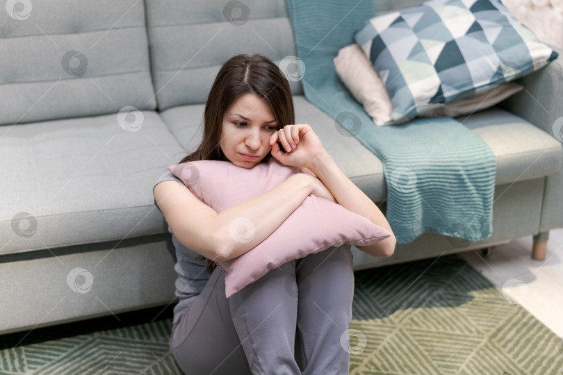 Скачать На полу сидит женщина с подушкой на коленях фотосток Ozero