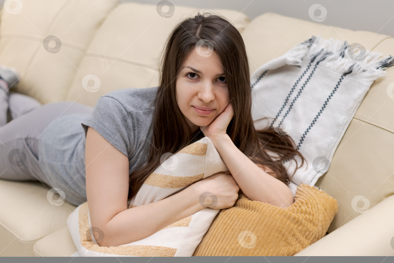 Скачать Женщина лежит на диване с подушкой на голове фотосток Ozero