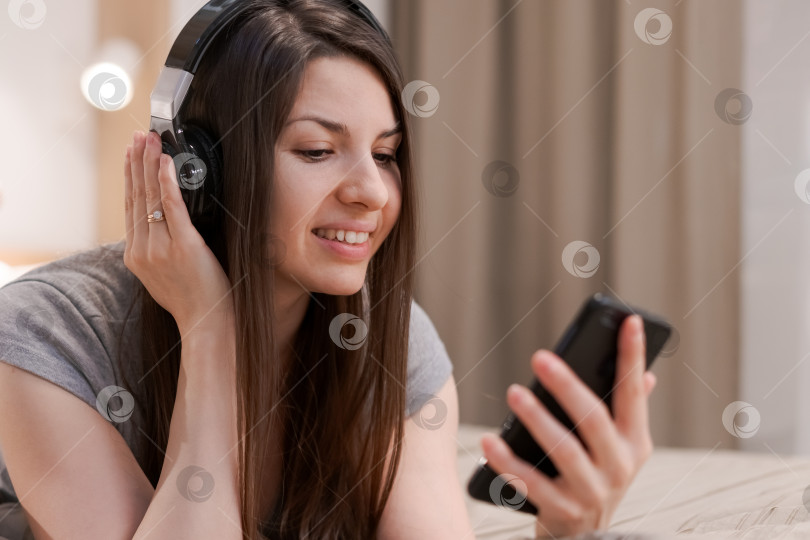 Скачать Женщина лежит на столе с телефоном в руке фотосток Ozero