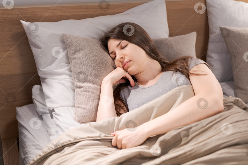 Скачать Женщина спит на кровати с подушкой на голове фотосток Ozero