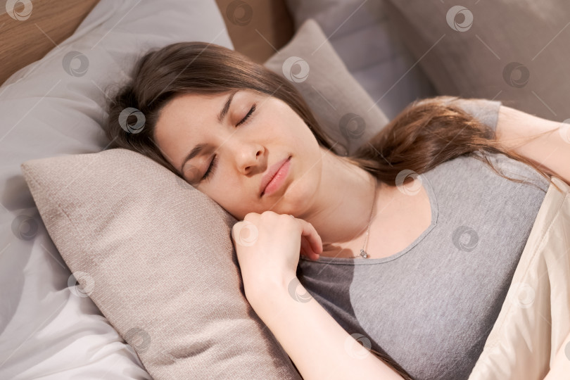 Скачать Женщина спит на кровати, подложив под голову подушку фотосток Ozero