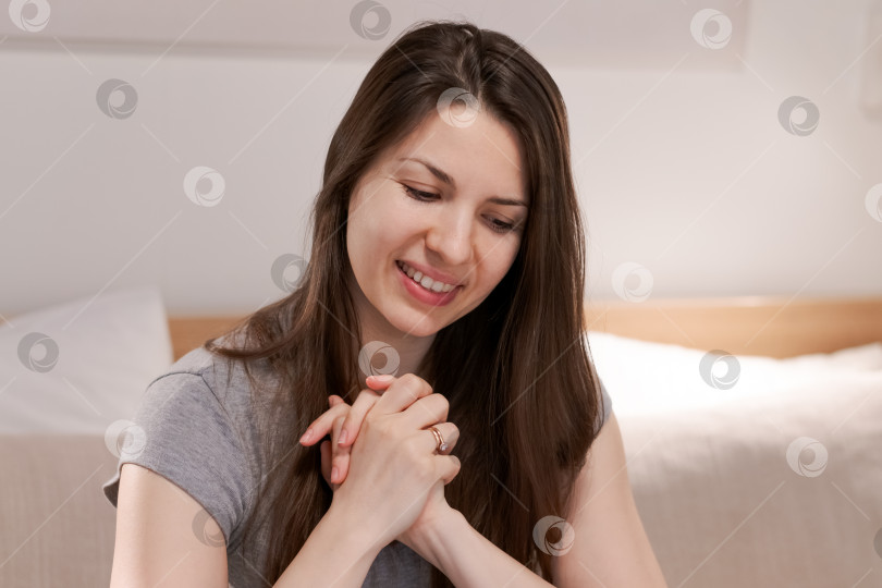 Скачать Женщина сидит на диване и молится фотосток Ozero