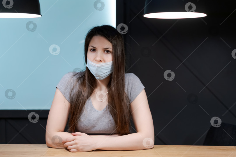Скачать За столом сидит женщина в маске фотосток Ozero
