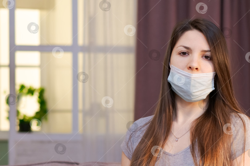 Скачать На диване сидит женщина в маске фотосток Ozero
