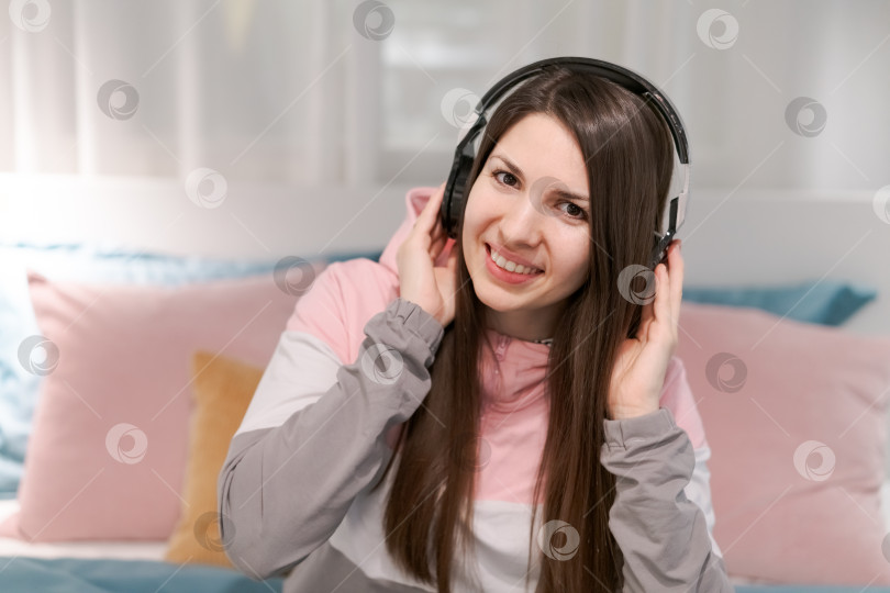 Скачать Женщина в наушниках и серо-розовой рубашке фотосток Ozero