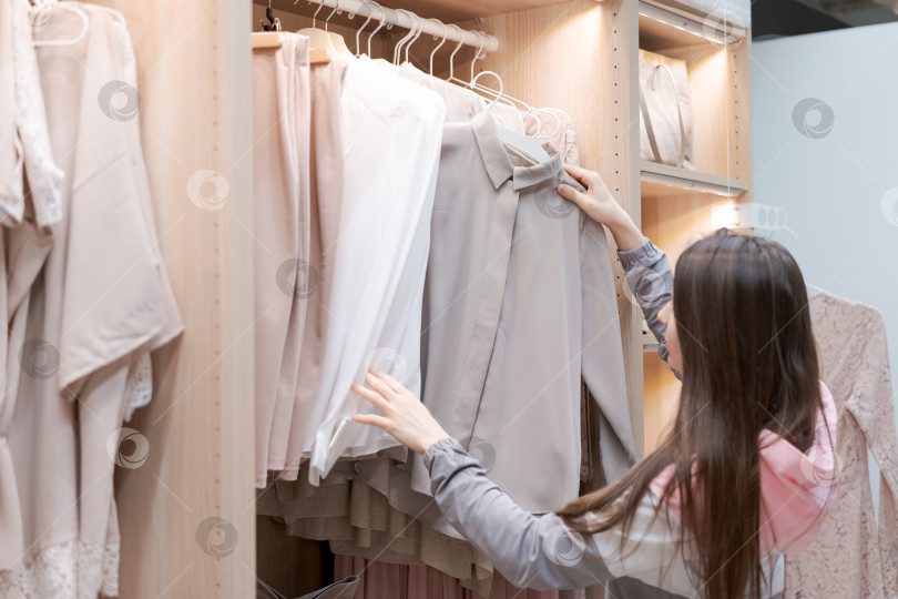 Скачать Женщина покупает одежду в магазине фотосток Ozero