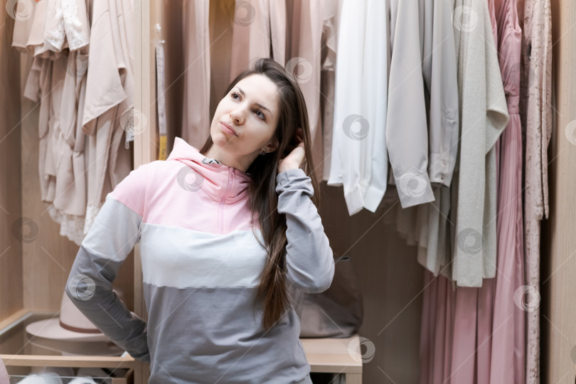 Скачать Женщина стоит перед шкафом, полным одежды фотосток Ozero