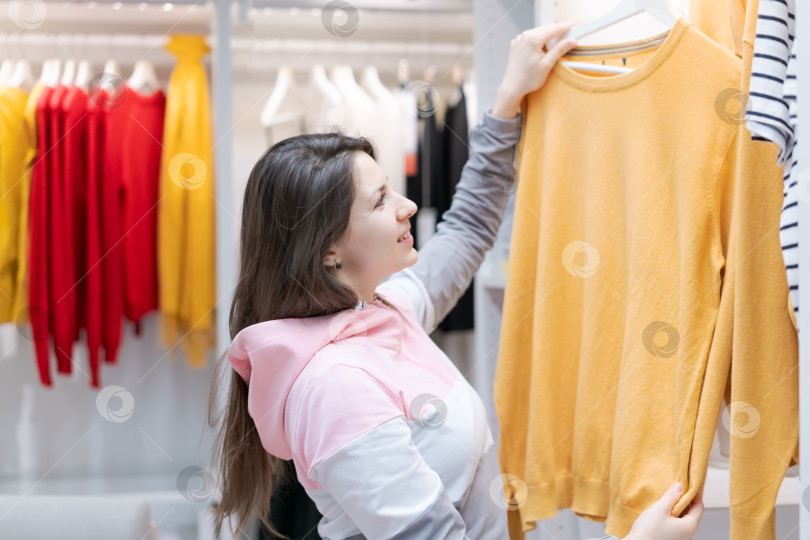 Скачать Женщина покупает одежду в магазине фотосток Ozero
