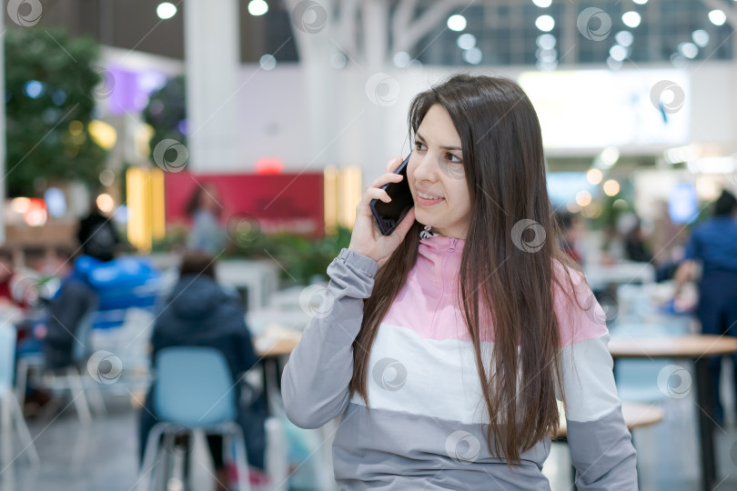 Скачать Женщина разговаривает по мобильному телефону в ресторане фотосток Ozero