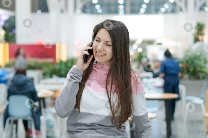 Скачать Женщина разговаривает по мобильному телефону в ресторане фотосток Ozero