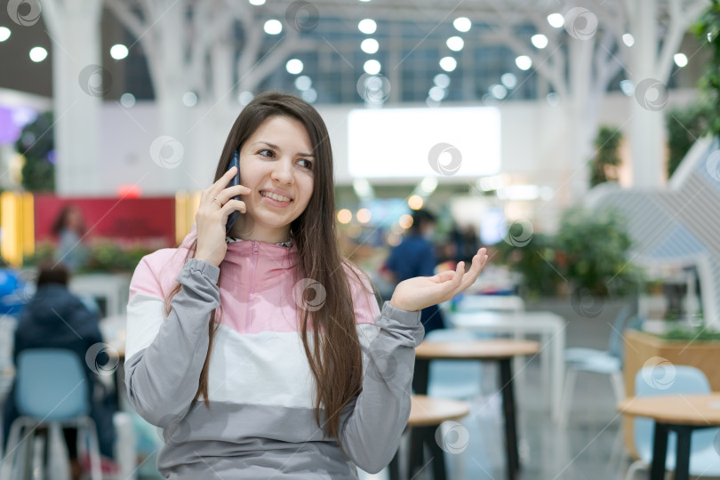 Скачать Женщина разговаривает по мобильному телефону в ресторане фотосток Ozero