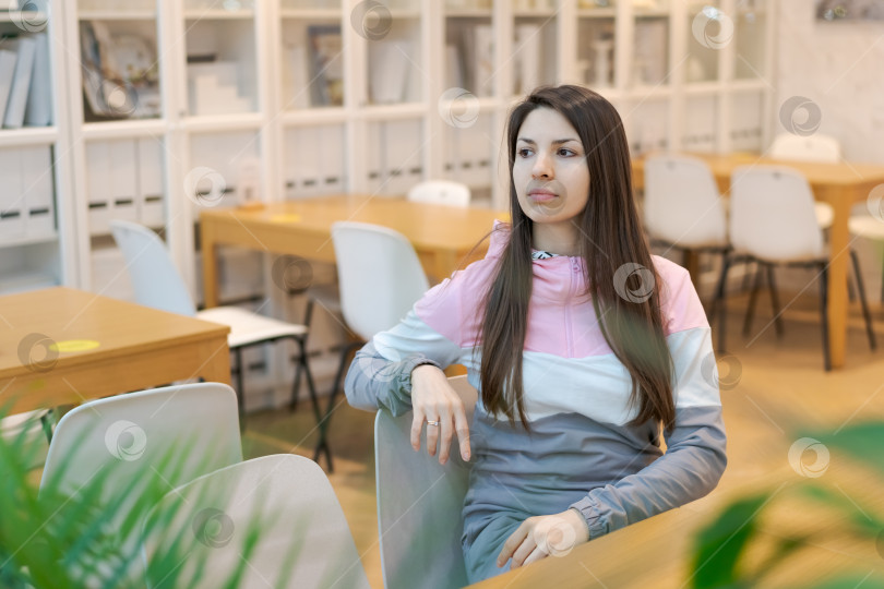 Скачать Женщина сидит в кресле в библиотеке фотосток Ozero