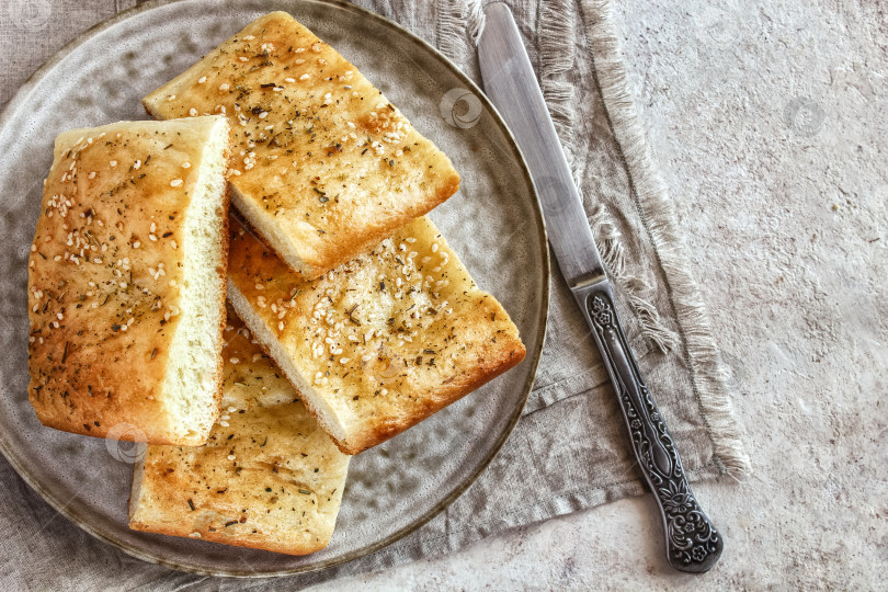 Скачать Фокачча со специями на керамическом блюде нарезанная кусочками, вид сверху избирательный фокус. фотосток Ozero