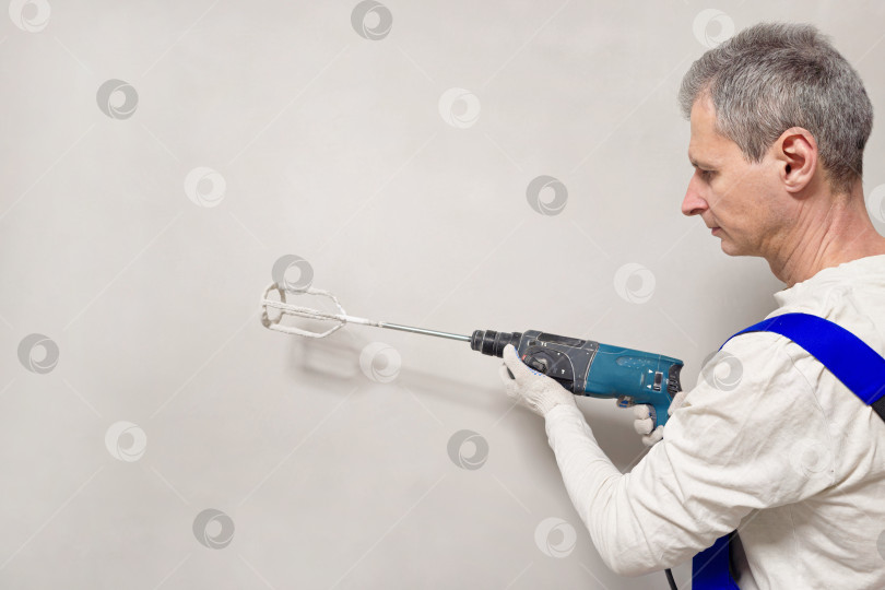 Скачать Рабочий с ручной электрической бетономешалкой фотосток Ozero