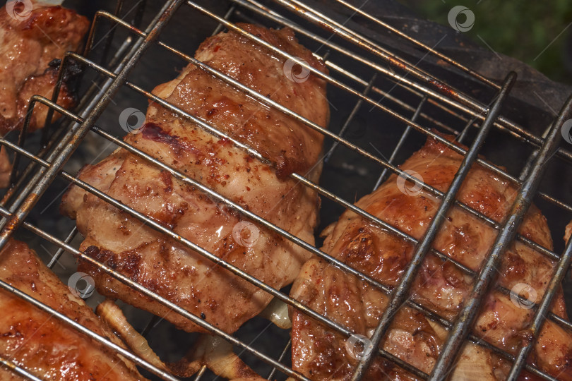 Скачать Кусочки курицы с золотистой корочкой обжариваются на гриле над углями. фотосток Ozero