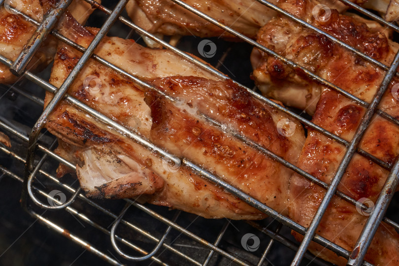 Скачать Кусочки курицы с золотистой корочкой обжариваются на гриле над углями. фотосток Ozero