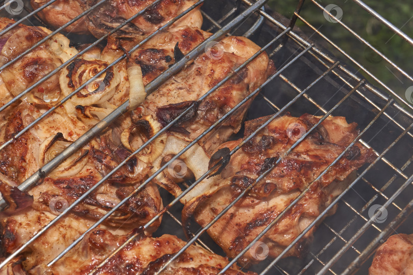 Скачать Кусочки курицы с золотистой корочкой обжариваются на гриле над углями. фотосток Ozero
