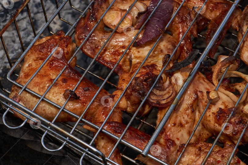 Скачать Кусочки курицы с золотистой корочкой обжариваются на гриле над углями. фотосток Ozero