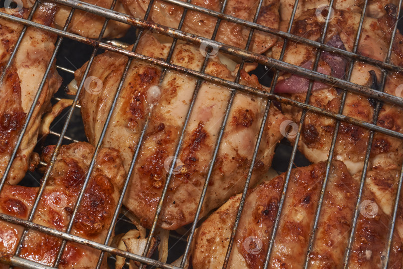 Скачать Кусочки курицы с золотистой корочкой обжариваются на гриле над углями. фотосток Ozero