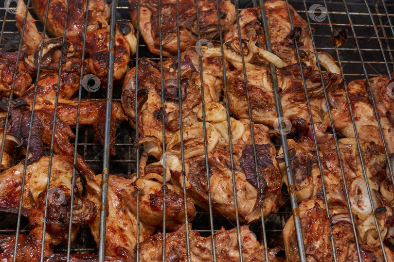 Скачать Кусочки курицы с золотистой корочкой обжариваются на гриле над углями. фотосток Ozero