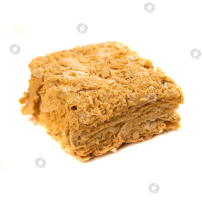 Скачать Полезный кусочек торта "Наполеон" без сахара, приготовленный из слоеного теста и легкого крема на белом фоне. Концепция низкокалорийного фитнес-десерта. фотосток Ozero