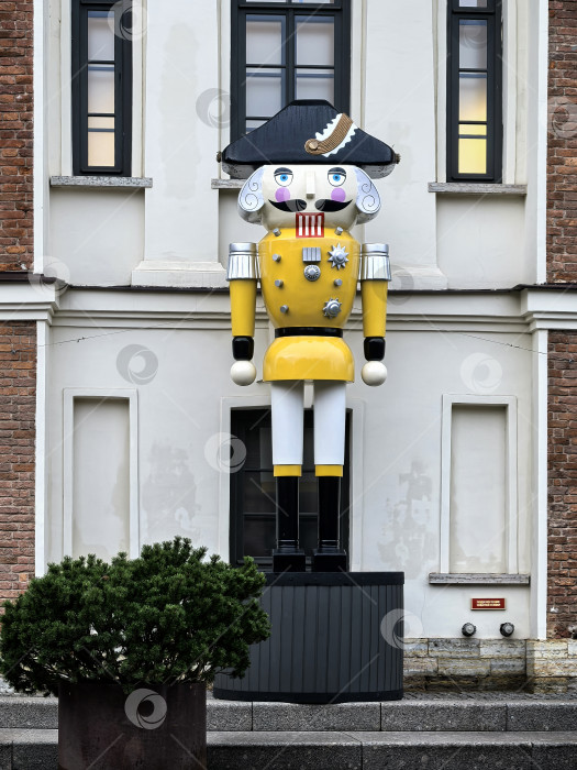 Скачать Санкт-Петербург, Россия - 17 декабря 2025 года. Гигантская статуя Щелкунчика перед историческим зданием. Снимок сделан на смартфон. фотосток Ozero