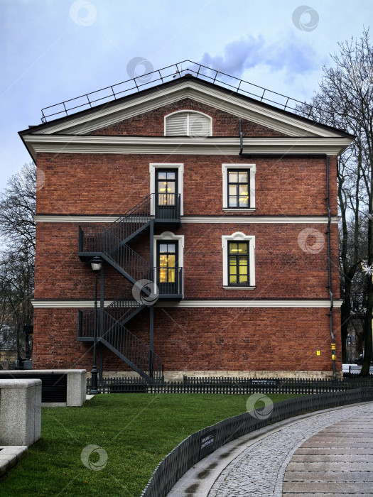 Скачать Кирпичное здание с металлической лестницей в сумерках. Снимок сделан на смартфон. фотосток Ozero