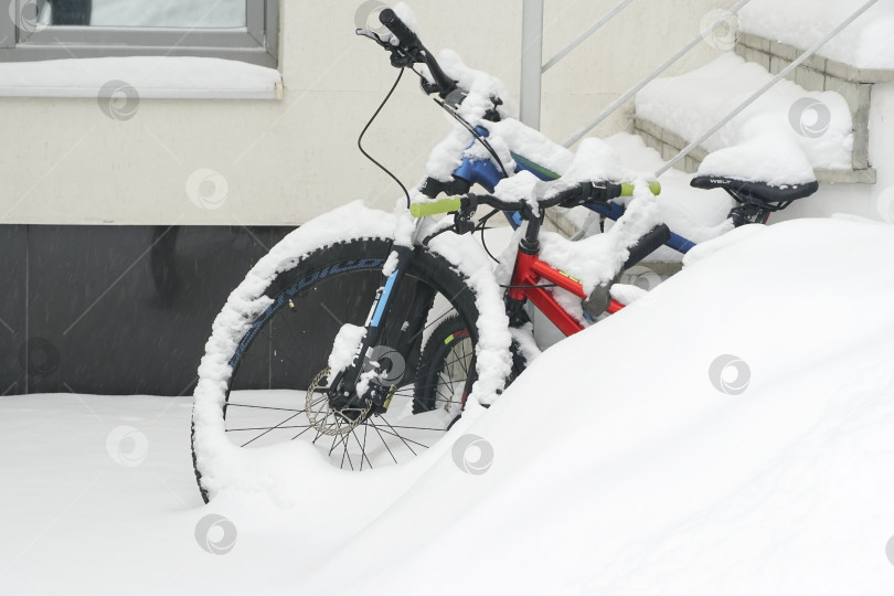 Скачать Велосипеды, стоящие в сугробе около дома, засыпаны снегом. Русская зима. Зима на Урале. фотосток Ozero