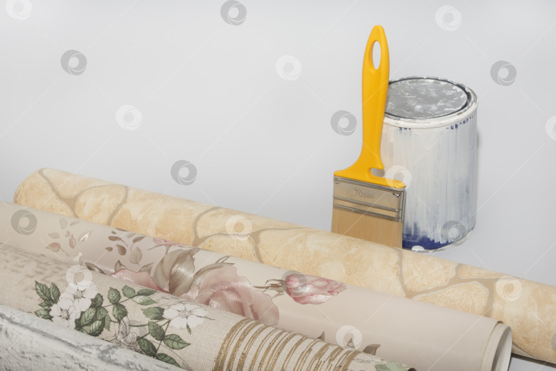 Скачать Рулоны разноцветных обоев, баллончик с краской и кисть на белом фоне. Концепция ремонта дома или квартиры фотосток Ozero