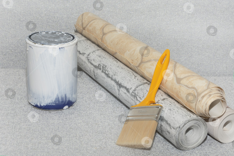 Скачать Текстурированные обои, банка белой краски и кисть на сером фоне. Место для текста. Концепция ремонта дома или квартиры фотосток Ozero