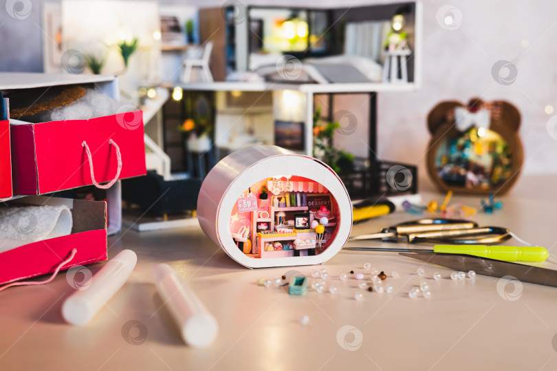 Скачать Клей и бусины для украшения крошечного домика на столе фотосток Ozero