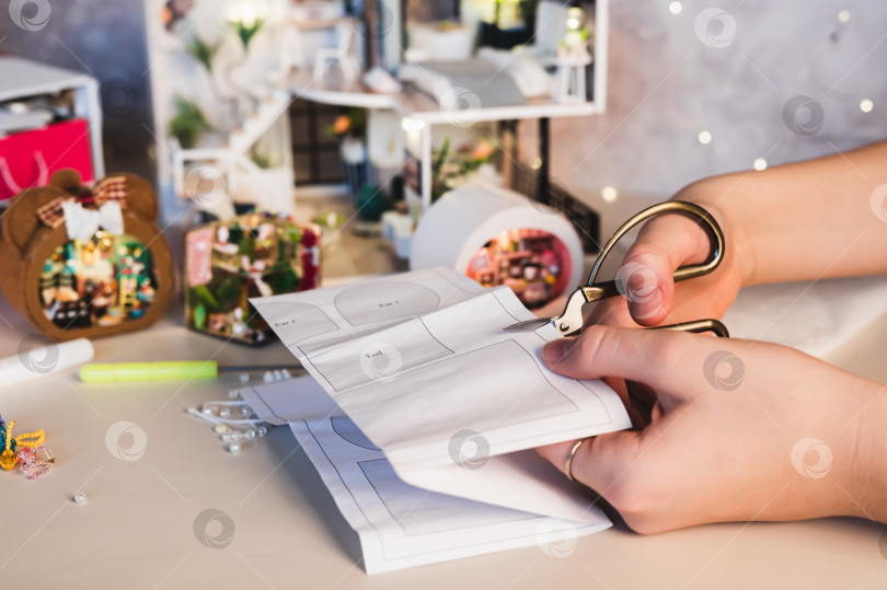 Скачать Девушка вырезает из бумаги выкройку коробки для комнаты фотосток Ozero