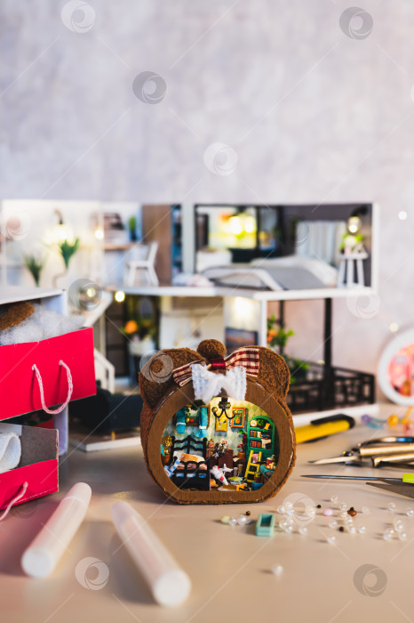 Скачать Клей и бусины для украшения крошечного миниатюрного домика на столе в вертикальном положении фотосток Ozero