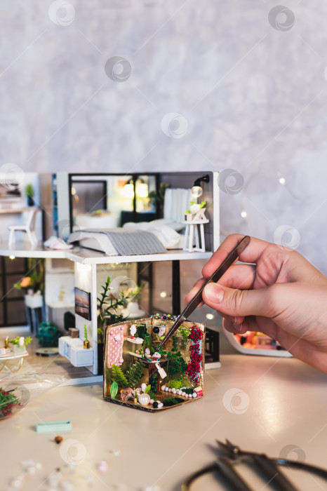 Скачать Девушка с помощью пинцета помещает растение в крошечный комнатный ящик в вертикальном положении фотосток Ozero