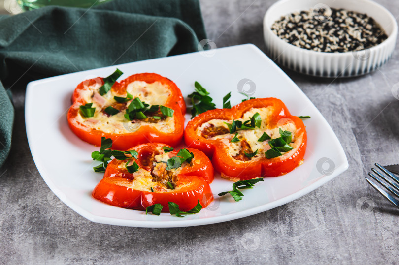 Скачать Обжаренные кольца красного болгарского перца с омлетом и зеленью на тарелке на столе фотосток Ozero