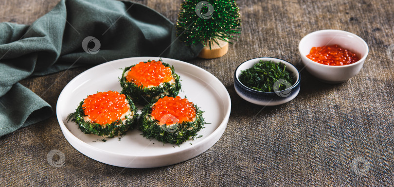 Скачать Оригинальные маленькие бутерброды со сливочным маслом и красной икрой на тарелке на веб-баннере стола фотосток Ozero