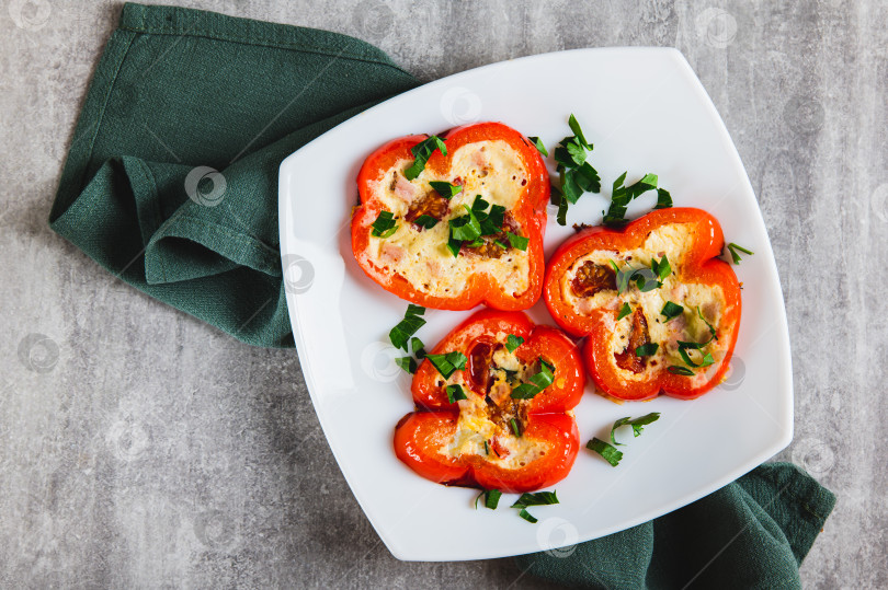 Скачать Крупный план обжаренных колец красного болгарского перца с омлетом и зеленью на тарелке на столе вид сверху фотосток Ozero