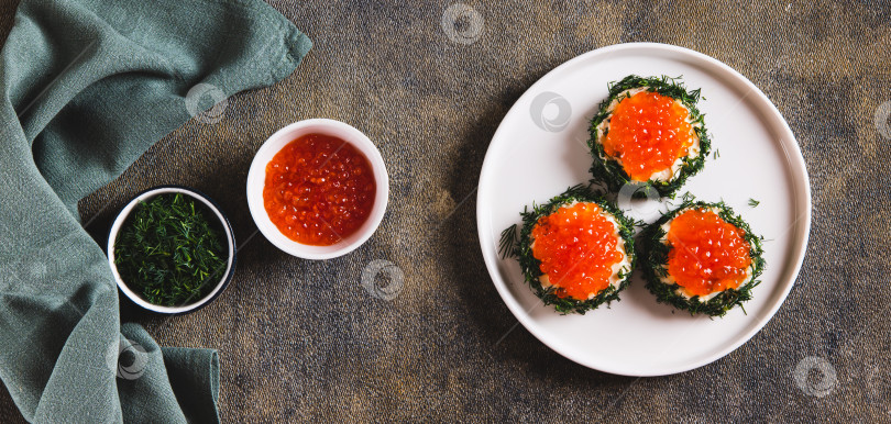 Скачать Креативные мини-бутерброды с красной икрой, сливочным маслом и укропом на тарелке вид сверху на веб-баннер фотосток Ozero