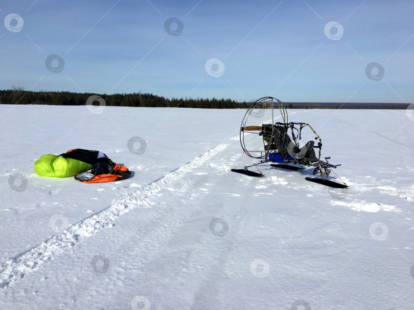 Скачать Моторный параплан, паратрайк на заснеженном поле. Подготовка ко взлету. Ясный зимний солнечный день. фотосток Ozero