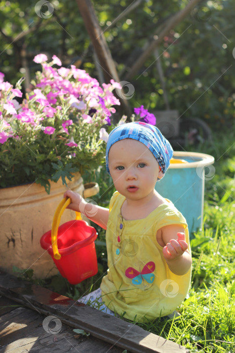 Скачать Маленькая девочка играет в саду фотосток Ozero