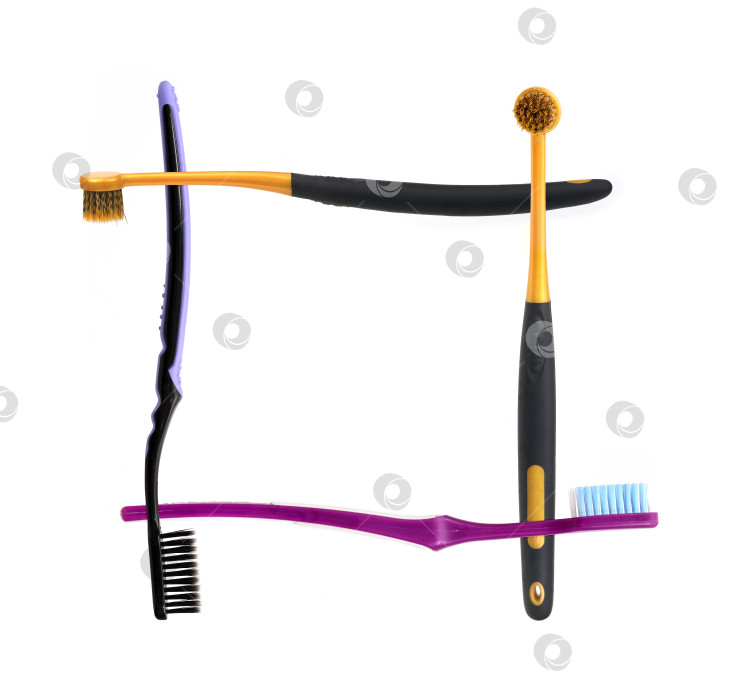 Скачать Четыре разные зубные щетки, образующие рамку на белом фоне, готовы к съемке. Чрезвычайно высокое разрешение фотосток Ozero