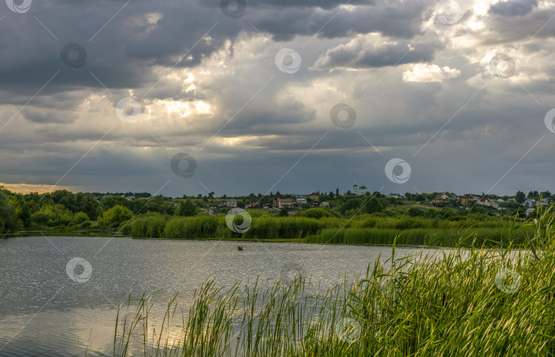 Скачать закатное небо над рекой, на заднем плане деревня с церковью фотосток Ozero